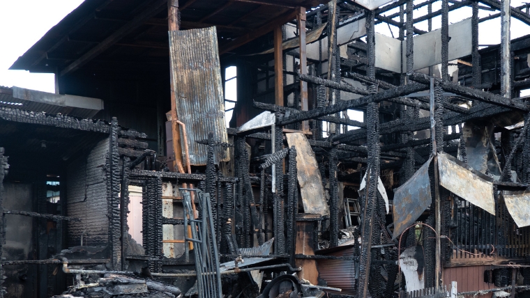 近所の火事によって外壁が焦げた民家の様子を示す写真