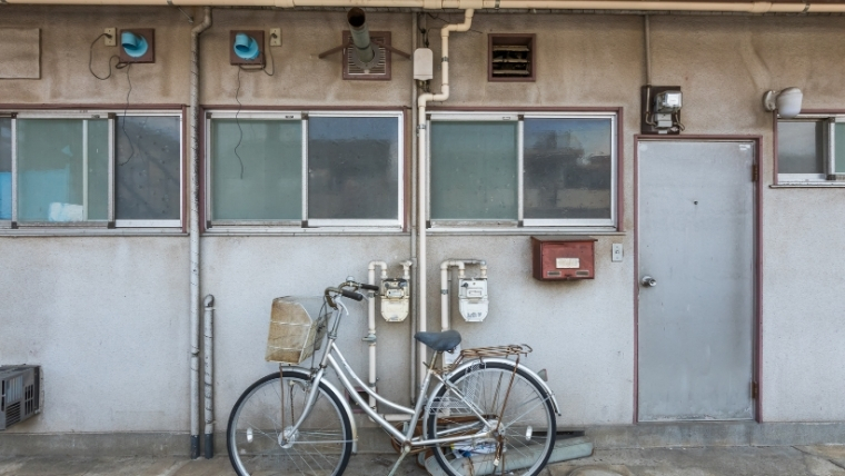 夜逃げ後の残置物が放置された、廃アパートの部屋前の様子を写した写真