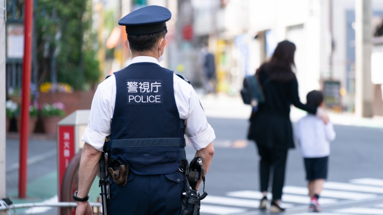 警視庁と記されたベストを着用した警察官と思われる人物の後ろ姿。孤独死発見後に警察へ通報・検視が行われる流れを想起させるイメージ