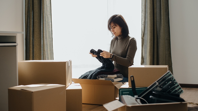 身辺整理を始める際の心構えを解説する章で使用する、女性が荷物を整理している様子の写真