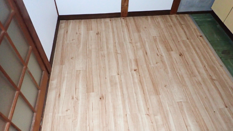 片付け・清掃完了後の和室。畳が撤去され、清潔な木目のフローリングが張られた自社施工後の室内