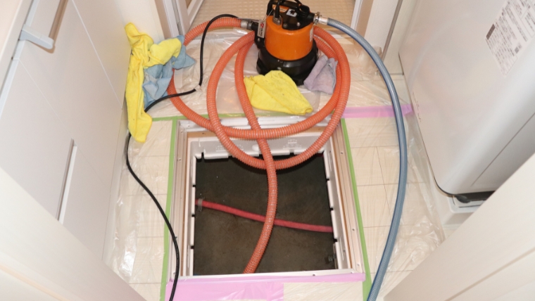 床下浸水対応で家庭用排水ポンプ実際に設置して使用している様子の写真