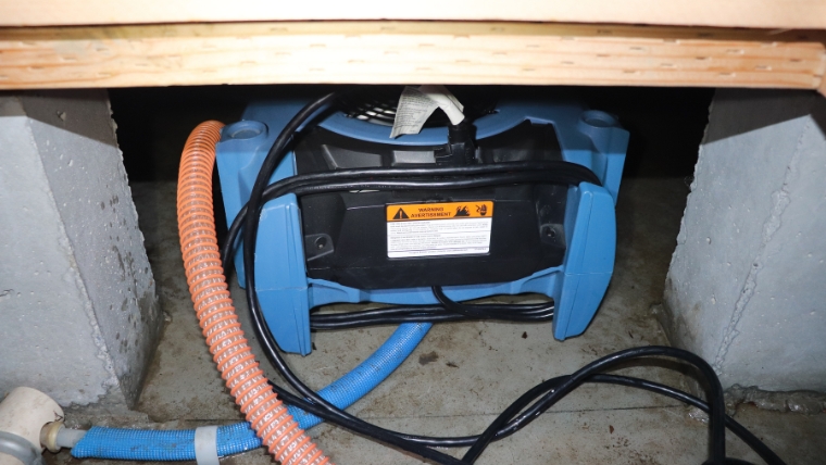 床下浸水後に拡散送風機を稼働させ、床下空間をしっかり乾燥させている作業の様子