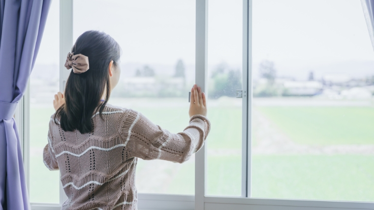 女性と思われる人物が室内で窓を開けて換気しているイメージ。強烈な匂いを発生させないための日常的な換気対策を想起させる