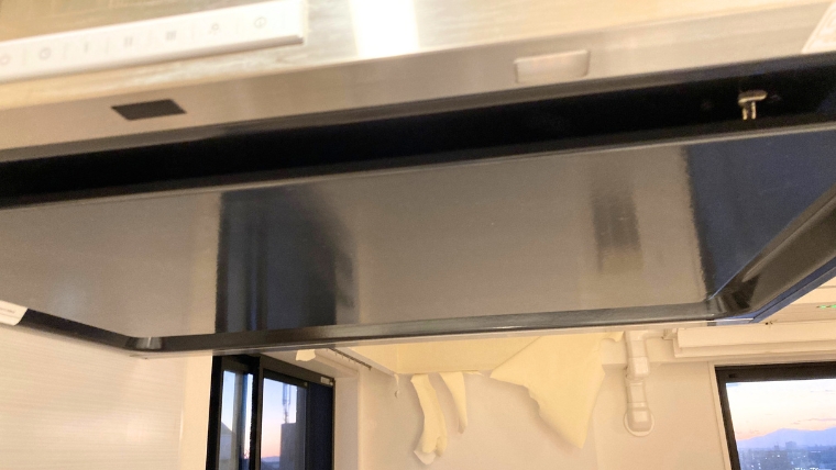 自社スタッフが撮影したキッチンのレンジフード清掃後の様子。ステンレス製フード内部が清潔に清掃された実際の現場写真