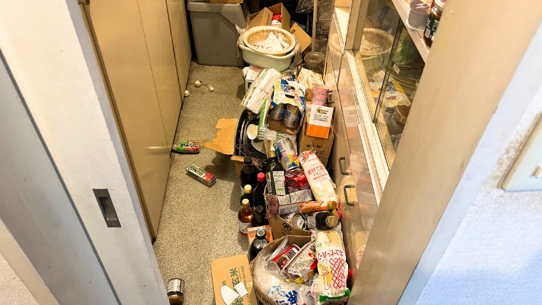 自社スタッフが撮影したキッチン通路。調味料・食品・段ボールが床一面に散乱した実際の現場写真