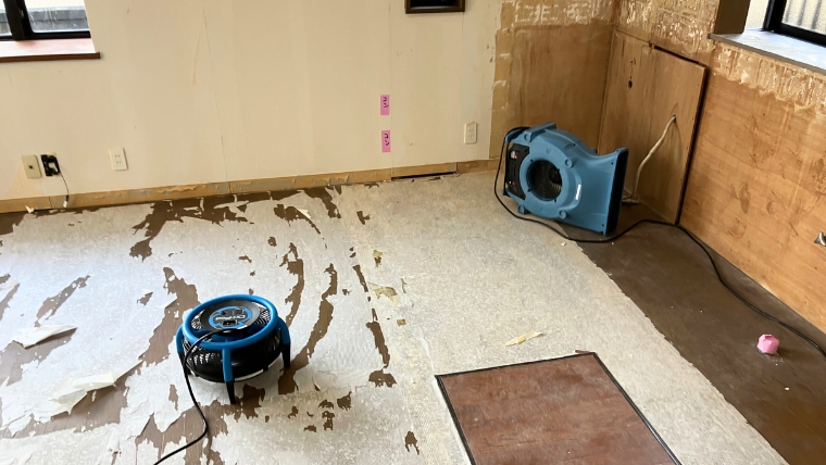 プロペラ付きの青い機材を床に置いている様子