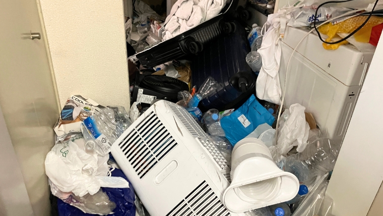 居室内に小型家電や生活雑品が積載されている様子
