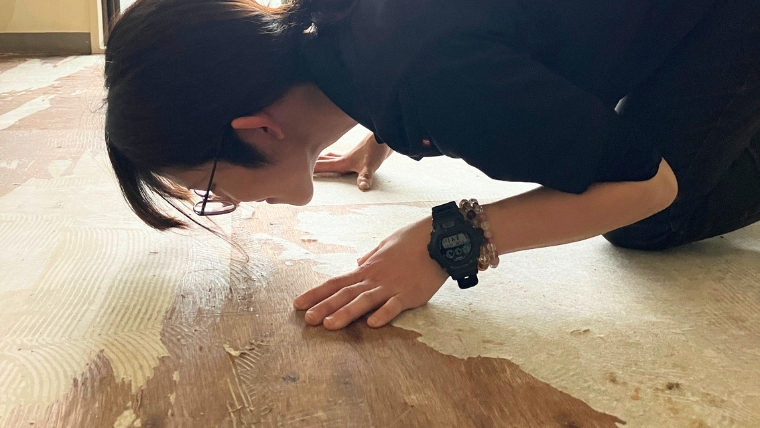 自社スタッフが床に顔を近づけて確認しているう様子