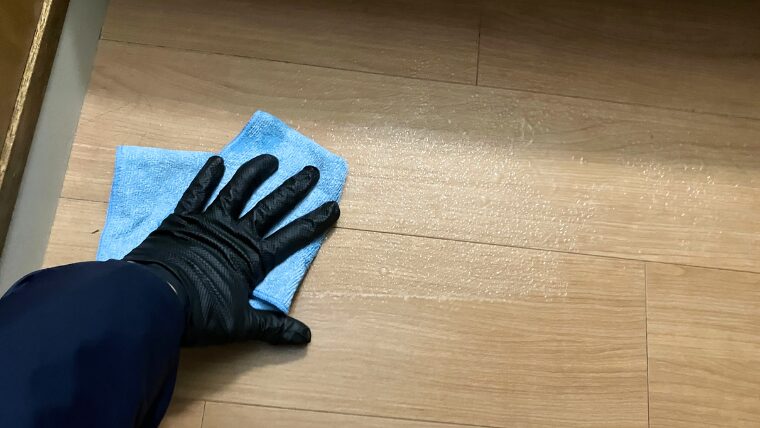 黒いグローブを装着し床面を拭き上げる様子